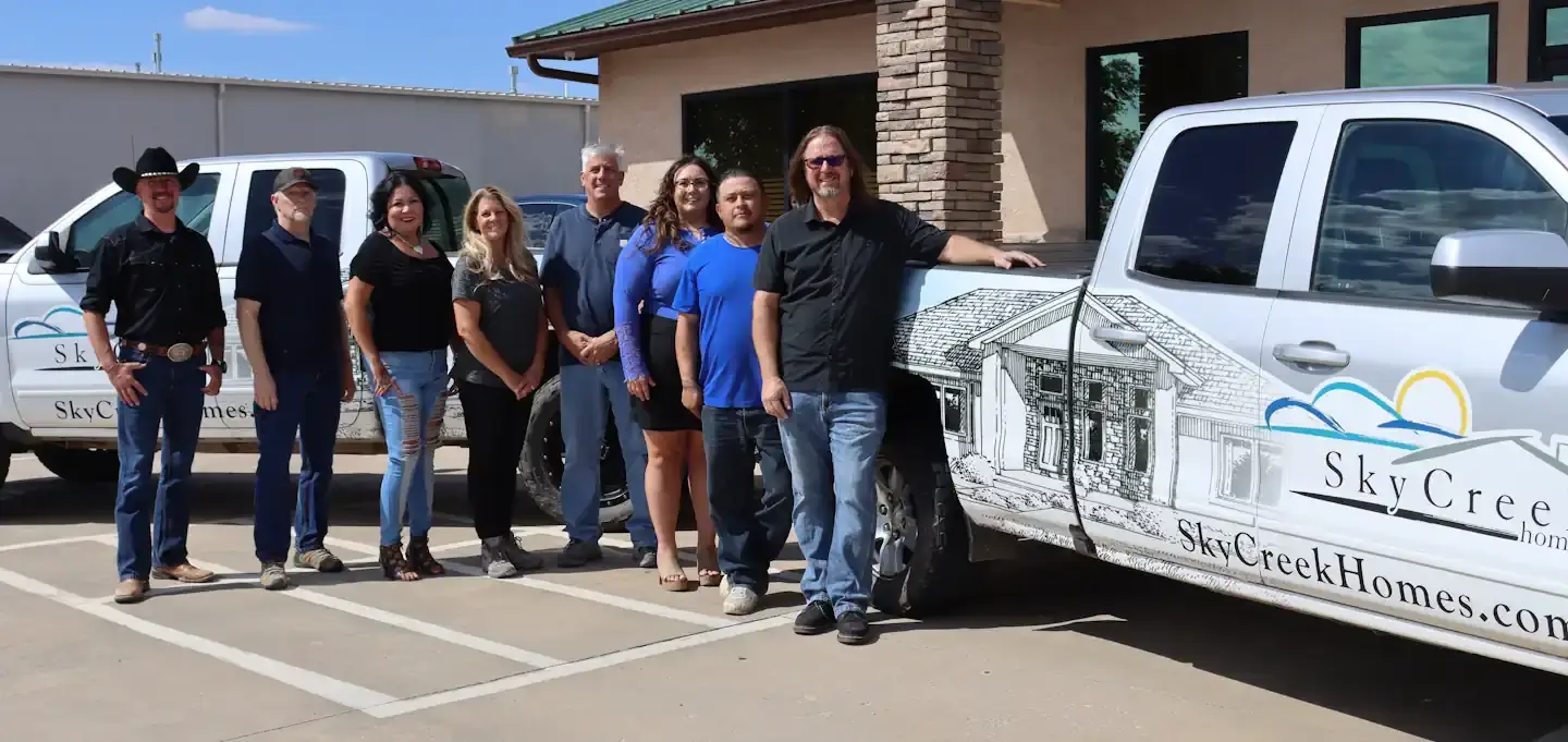 The employees of Sky Creek Homes The Sky Creek Homes employees standing in front of the Sky Creek Home trucks.