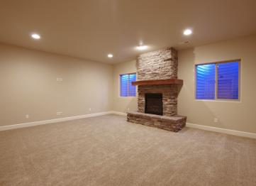 A stone fireplace becomes the focal point of a basement family room.